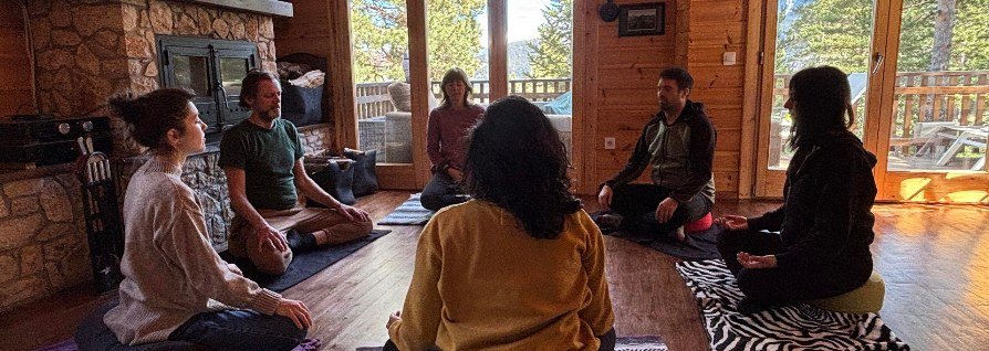 Grupo meditando en círculo junto a la chimenea